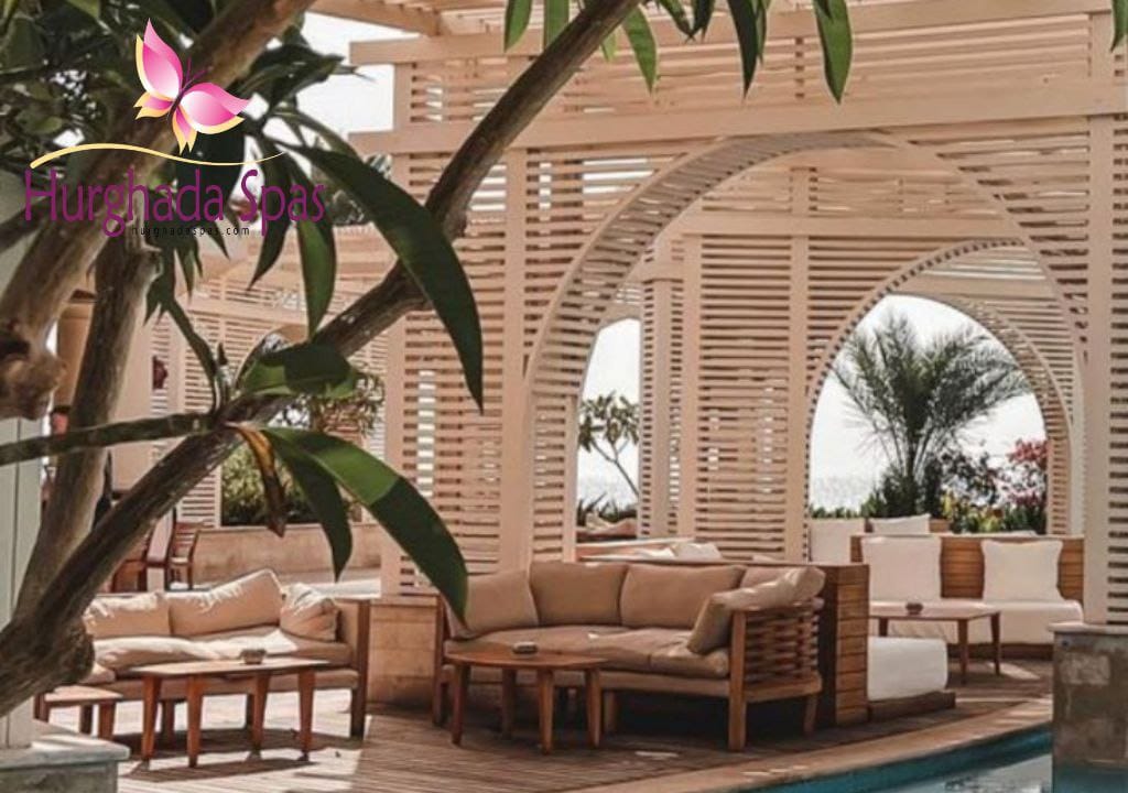 Elegant outdoor lounge area at Paradise Spa with wooden pergolas, comfortable beige sofas, and poolside greenery creating a relaxing atmosphere